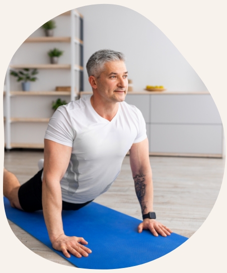 Smiling older man exercising on machine at gym